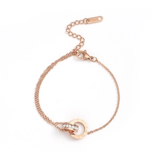 Macro detail of rose gold interlocked double rings with Roman numerals and crystals