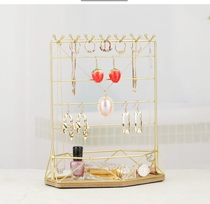 Detailed view of gold metal jewelry organizer with hooks and geometric base tray