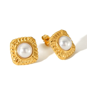 Detail of vintage square gold stud earrings with large white pearl and textured frame
