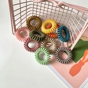 Close-up of colorful spiral telephone wire hair ties in various matte Morandi shades