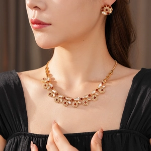 Close-up of vintage gold-tone necklace and round stud earrings set with brown zircons