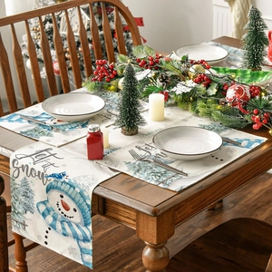 Detail showing Christmas table runner and placemat with blue snowmen on wooden table