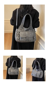 Gray large capacity tote bag with front pockets shown on model in a minimalist setting
