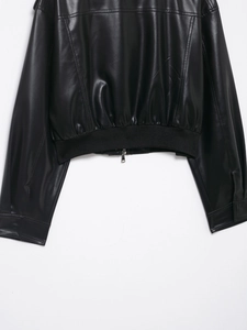 Detail von Rippbündchen und Saum an schwarzer Kunstlederjacke mit Silberreißverschluss
