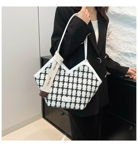 Close-up of black and white checkered tweed tote bag with chic ribbon charm detail