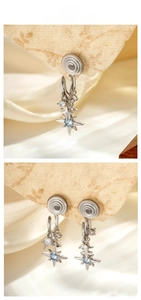 Macro detail of silver starburst clip-on earring with light blue gemstone and silk texture