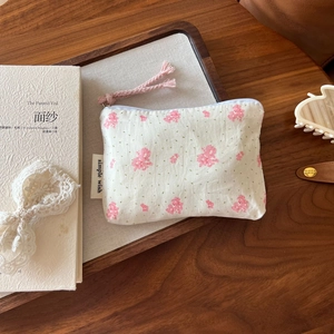 Detailed close-up of a floral cotton coin purse with zipper and simple wish label