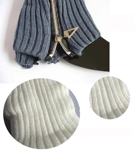 Detailed close-up of blue knitted leg warmers with metal zipper and white ribbed texture