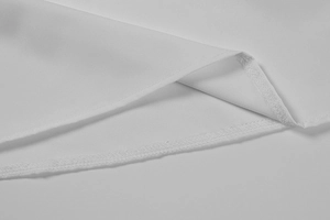 Gros plan détaillé montrant les coutures de l'ourlet du tissu de la robe blanche