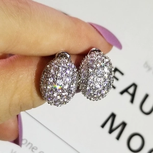 Macro shot of silver oval stud earrings paved with sparkling cubic zirconia crystals