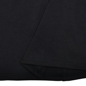 Close-up of the knitted fabric texture and fine stitching on the black dress hemline
