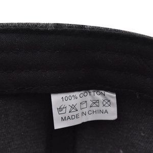 Detail of 100% cotton wash label with care symbols on black vintage baseball cap