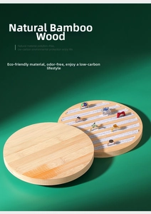 Detailed view of bamboo ring display tray with grey velvet slots on green background