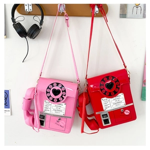 Close-up of retro dial telephone crossbody bags in glossy pink and red patent leather