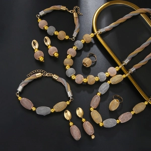 Detailed close-up of tricolor woven mesh bead jewelry set in gold, silver and rose gold