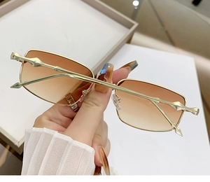 Detail of golden bamboo-shaped metal frame and brown gradient lenses on vintage sunglasses