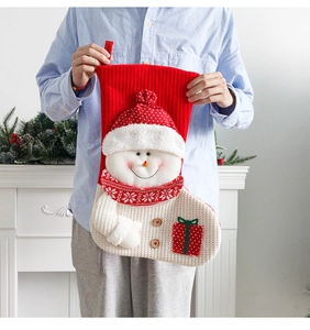 Close-up of large red knitted Christmas stocking with snowman design and button details