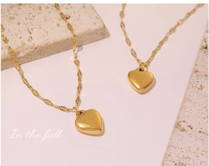 Close-up of dual heart pendant bracelets in 18k gold plated titanium steel finish