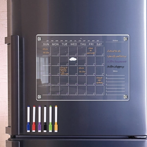 Detailed view of magnetic acrylic weekly planner on fridge with six colored markers