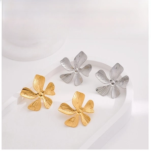 Detail of five-petal flower stud earrings in gold and silver with textured radial petals