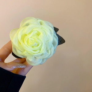 Detail der Organza-Blumen-Haarklammer mit Perlen-Staubbeuteln und weichen Blättern
