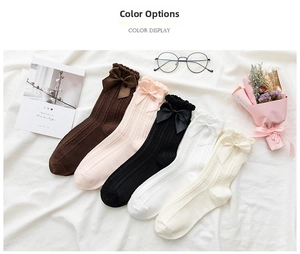 Flat lay of five colors of Japanese style crew socks with silk bow and ribbed texture