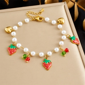 Detail of strawberry pearl bracelet with gold heart charm and crystal beads
