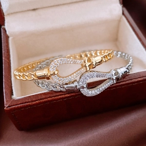 Macro shot of 18K gold plated and silver U-shaped horseshoe buckles with paved zircons
