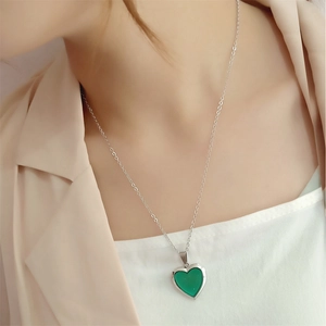 Close-up of heart-shaped temperature color changing pendant on silver steel chain