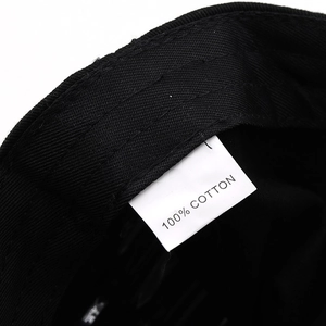 Detailed close-up of 100% cotton tag and premium stitching on black baseball cap