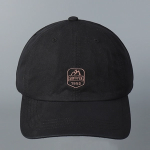 Close-up of black cotton baseball cap with detailed brown mountain peak embroidery