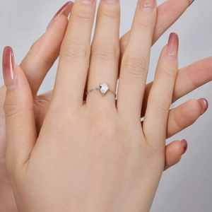 Detailed view of silver chain ring featuring a teardrop zircon gemstone on finger