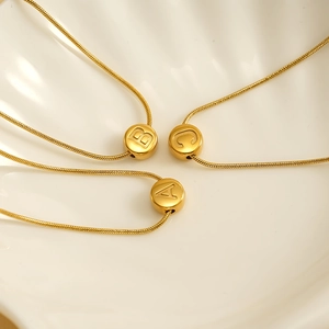 Gold stainless steel snake chain necklace featuring sliding alphabet letter pendants