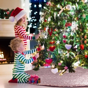Rose gold sequin Christmas tree skirt shown in a warm indoor holiday scene