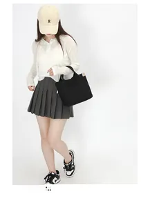 Detail of minimalist black canvas tote bag with contrast beige side webbing trim