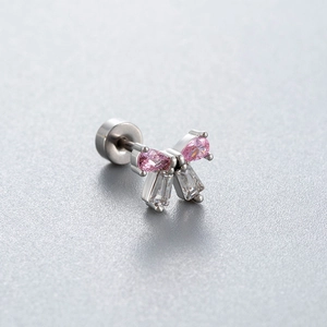 Pink zircon bow stud earring in titanium steel with screw back on a grey surface