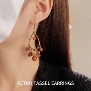 Bohemian teardrop tassel earrings with bronze metal finish and reddish brown beads