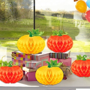 Fall harvest party decoration featuring five orange and yellow honeycomb paper pumpkins