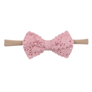 Close-up of pink crochet bow headband for babies with delicate knit texture