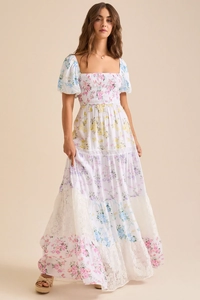 Détail de robe maxi fleurie blanche avec manches bouffantes et ourlet en dentelle étagé