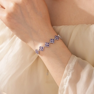 Detailed view of silver flower bracelet with purple crystals on a female wrist