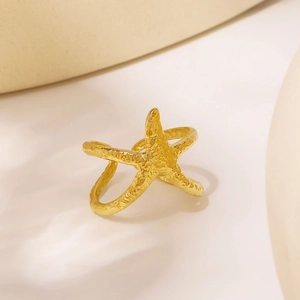 Golden starfish ring with hammered texture and double-layer open design on warm background