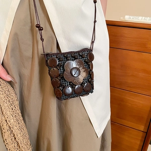 Detail of handmade coconut shell crossbody bag with large floral wooden button