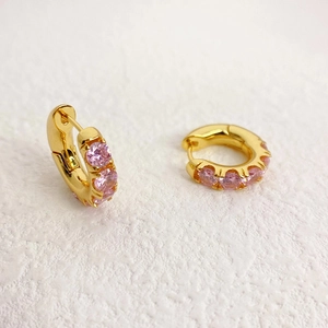 Detailed close-up of gold-plated hoop earrings featuring multiple inlaid pink zircons