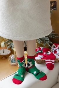 Close-up of thick coral fleece Christmas socks with cute elk patterns and warm texture