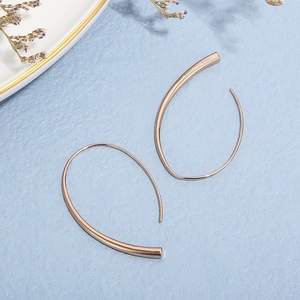Detailed view of modern rose gold irregular line earrings on elegant textured background