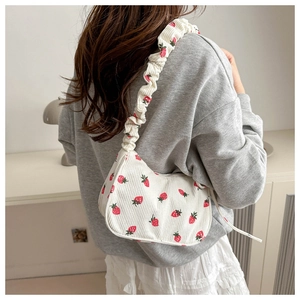 Detail of white corduroy shoulder bag with strawberry print and ruched strap