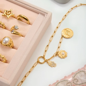 Close-up van gouden boze oog ringen en parelketting in roze fluwelen juwelendoosje