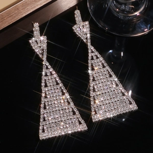 Sparkling geometric drop earrings with silver rhinestones on a black mirror background