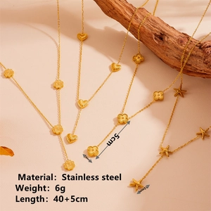 Collier doré en acier inoxydable avec trèfle, cœur et étoile de mer sur support en bois